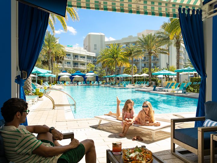 keluarga duduk di dekat cabana kolam renang