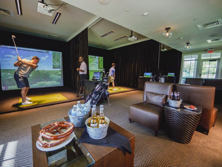 Man teeing off on indoor golfing simulator