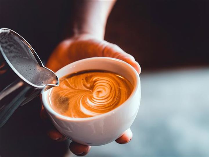 커피를 컵에 붓고 디자인을 만드는 사람