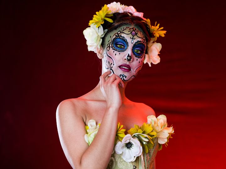 femme avec un crâne de sucre dia de los muertos peint sur son visage