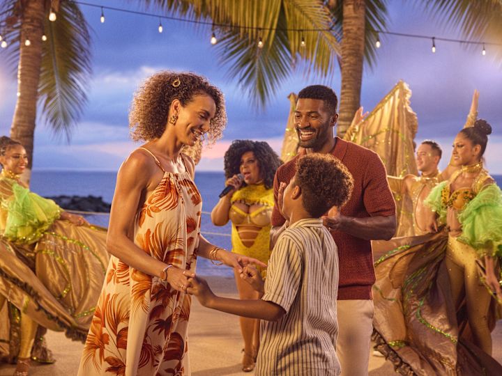 バンドやダンサーと夜のエンターテイメントを楽しむ母親、父親、息子