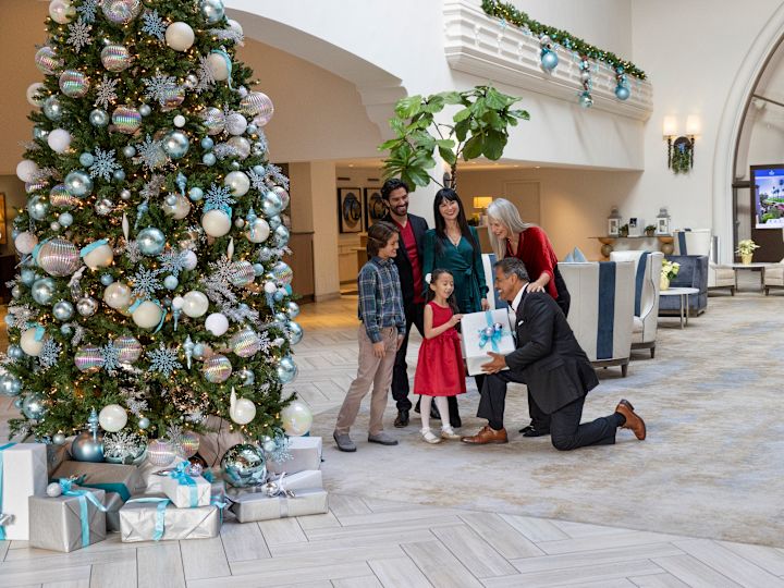 family in the hotel lobby decorated with a Christmas tree