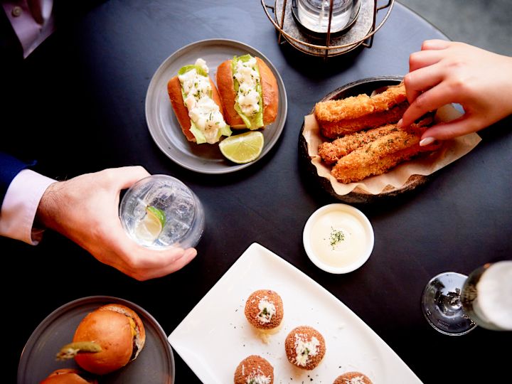 Top down view of peoples hands selecting various food on table