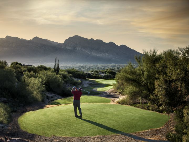 Гольфист на поле на закате