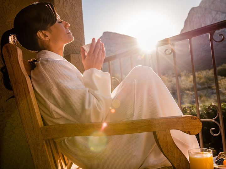 Žena odpočívající na balkóně s výhledem na kopce