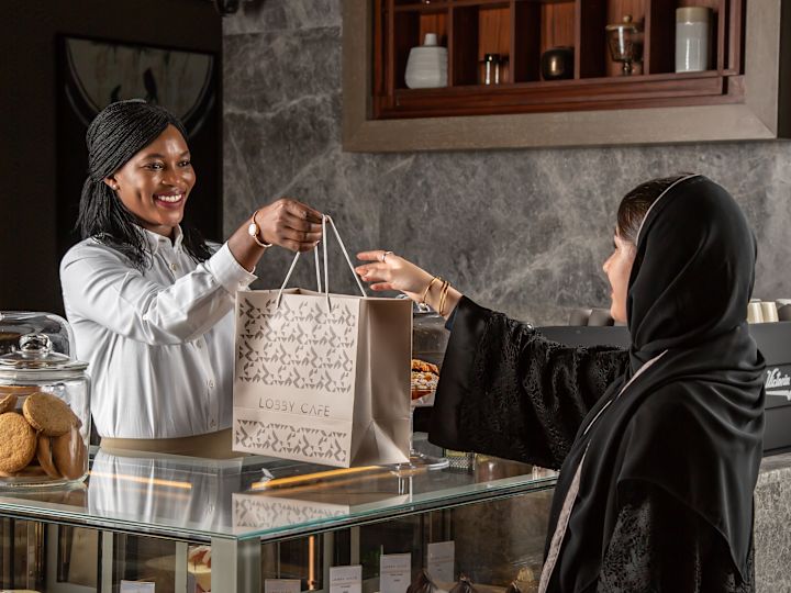 Lobby Cafe team member handing food bag to guest