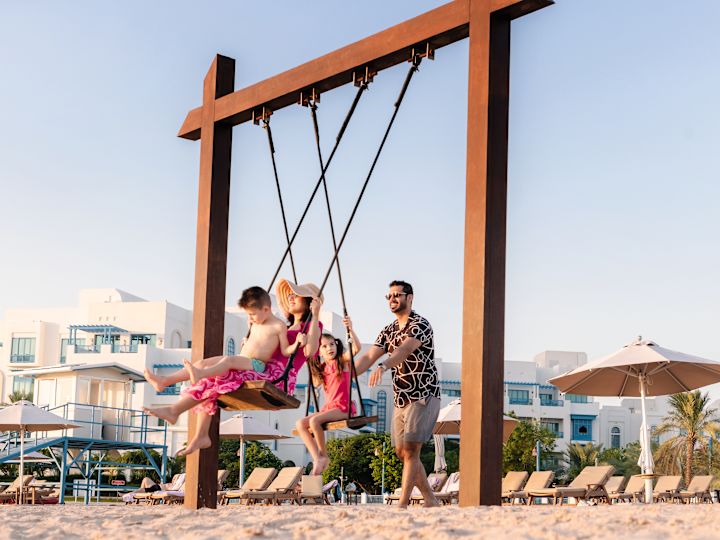 Famille jouant avec des swings sur la plage