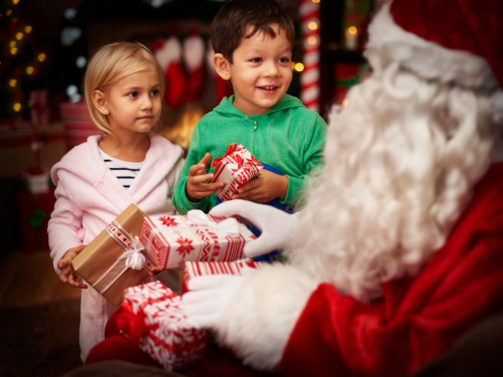 petit garçon et petite fille recevant des cadeaux de la part de Santa