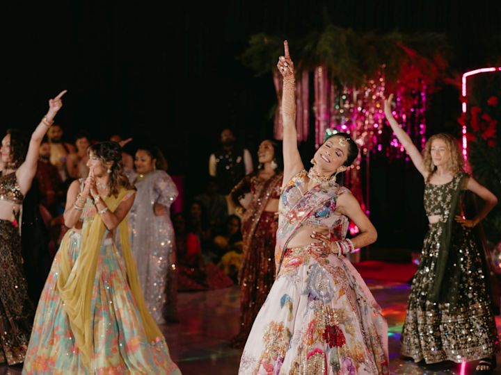 Dancing at wedding ceremony, with women holding hands aloft