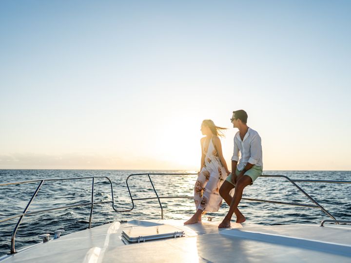 Couple Riding a Boat on the Water at Sunset