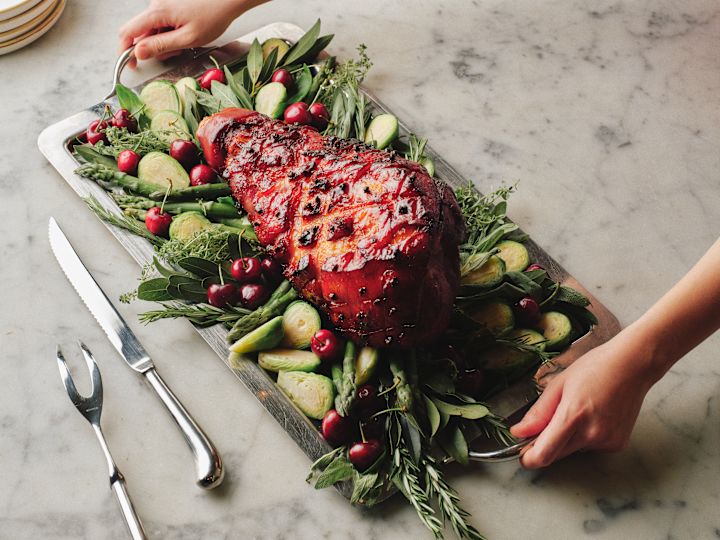 Chef Setting a  Tray with Ham and Vegetables  on a Table at the Glass Brasserie