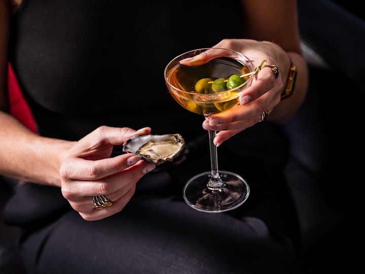 Femme avec des huîtres et un Martini au Zeta Bar