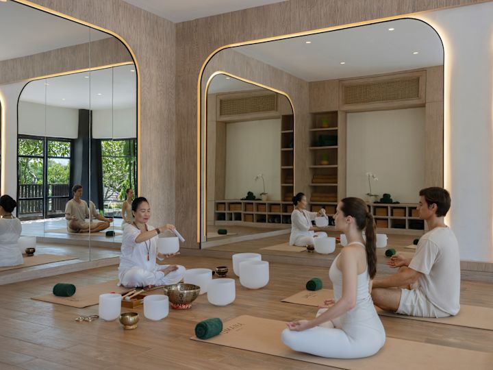 Mann und Frau werden von einem Kursleiter bei einer Audioheilung geführt