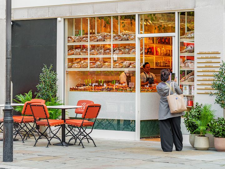 Woman Taking a Picture of EL&N Deli and Bakery Exterior