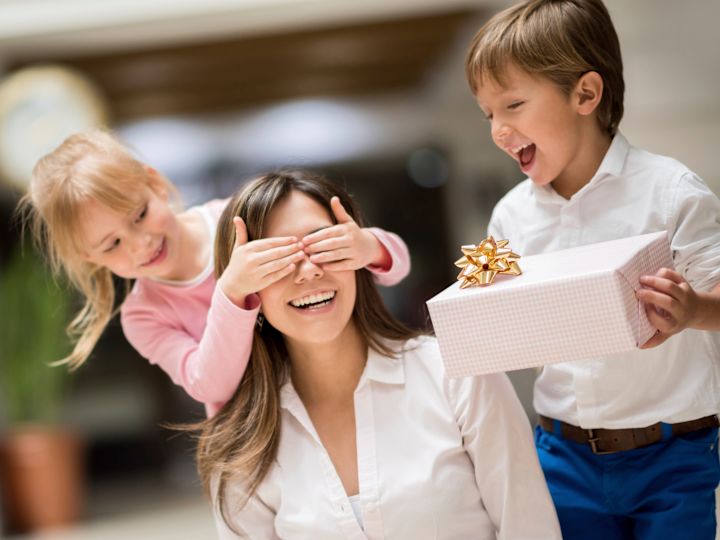 Copii care o suprind pe mama cu un cadou ambalat