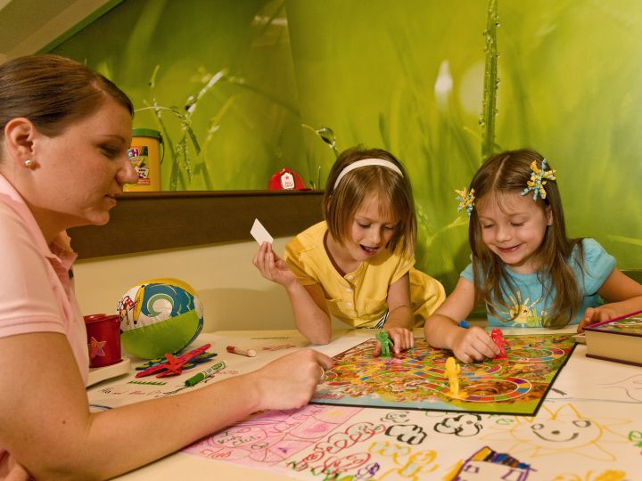 Two Girls and an Adult Playing a Game at Kids Club