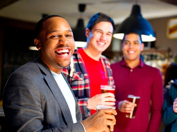 酒吧的男士欢笑和畅饮啤酒