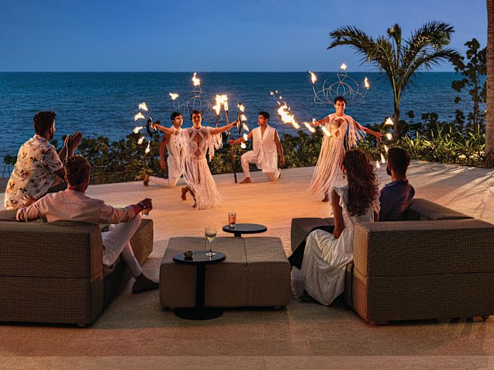 Group of people enjoying fire show outside by the beach