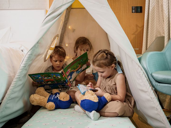 Enfants lisant dans une tente dans la chambre