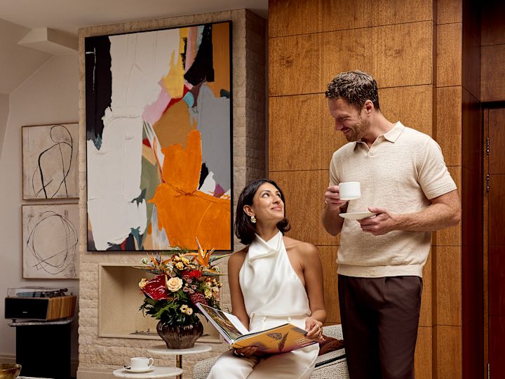 A smiling couple relax together in a suite