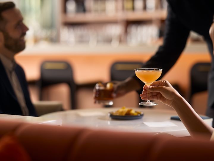 Adults drinking at round table by the bar