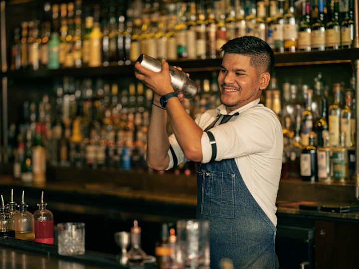 A bartender shaking a cocktail in Sire Bar