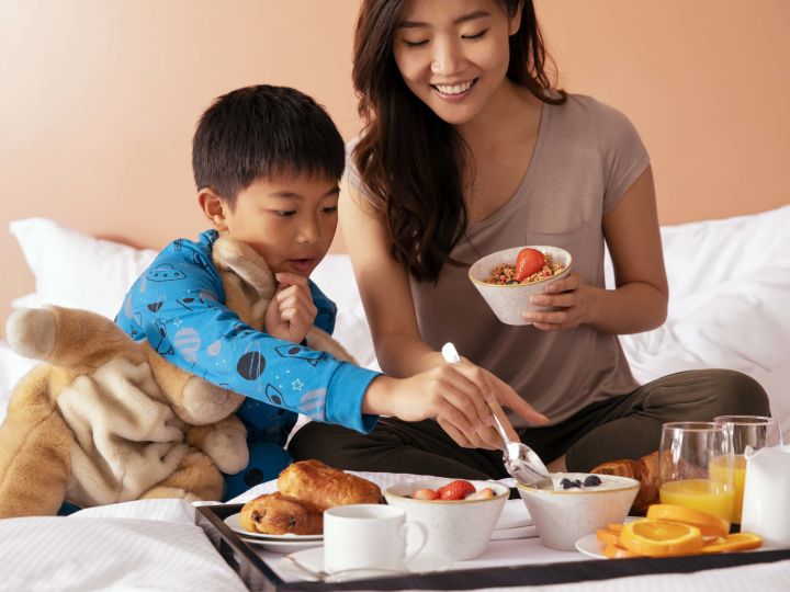 A mother and child having breakfast in bed