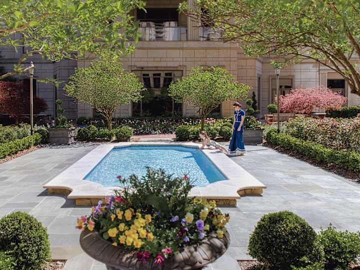 Outdoor pool area with trees and flowers