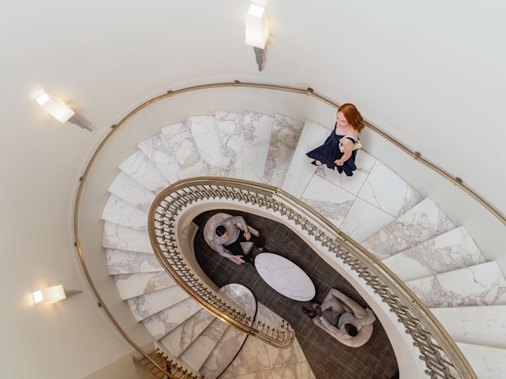 Lobby area with woman descending spiral staircase
