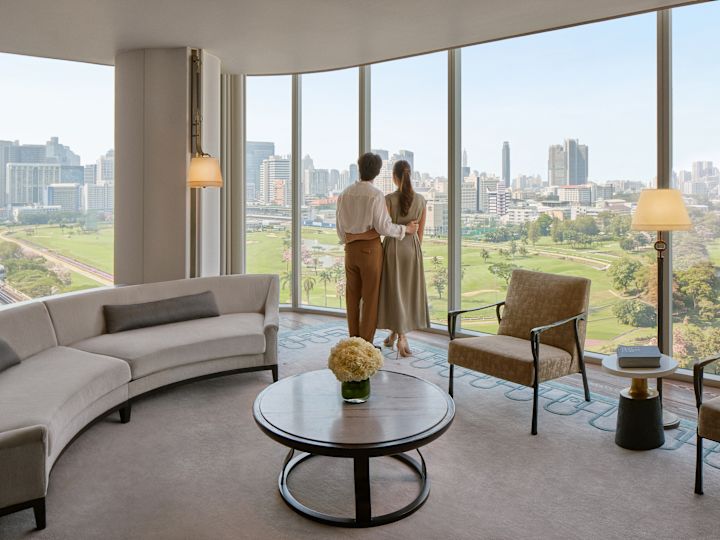 Un cuplu privind o fereastră în zona Lounge a camerei de oaspeți