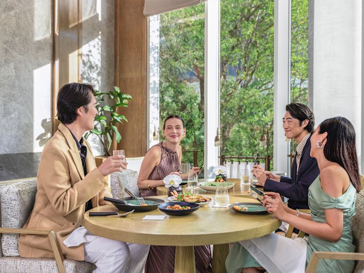 Группа людей, сидящих в зоне ресторана с едой