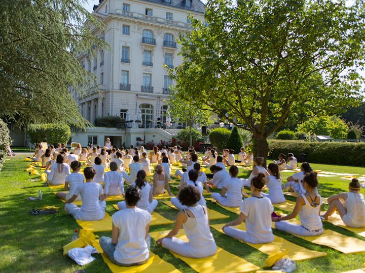 otelin bahçesinde yoga yapan bir grup insan