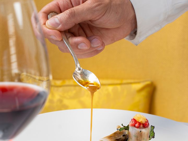 Gordon Ramsay au Trianon-Koch gießt Sauce auf das Gericht