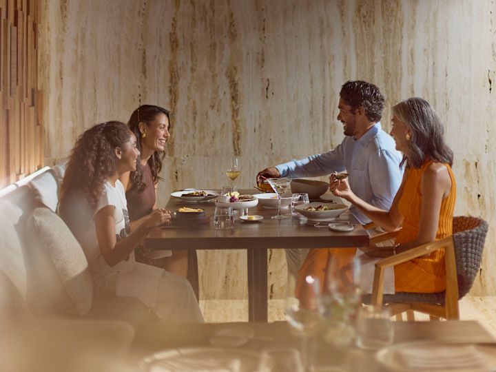 Mamă, tată, fiică și bunică bucurându-se împreună de cină