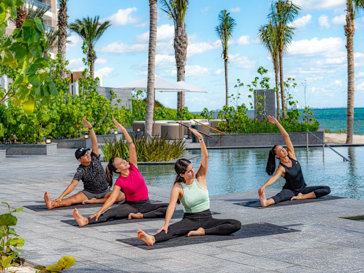 Menschen, die Yoga am Swimmingpool machen