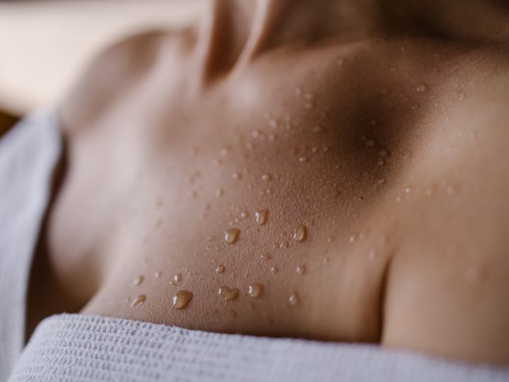 Closeup of droplets of water on woman's upper torso