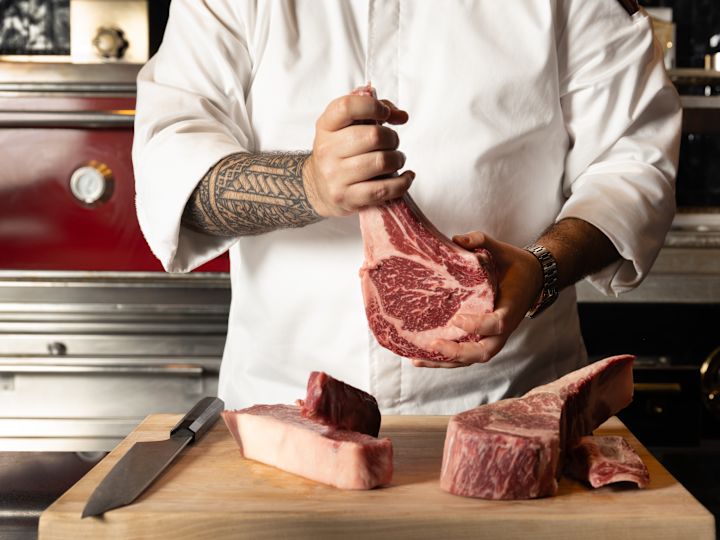 Chef Holding a Raw Steak at The Bazaar by José Andrés