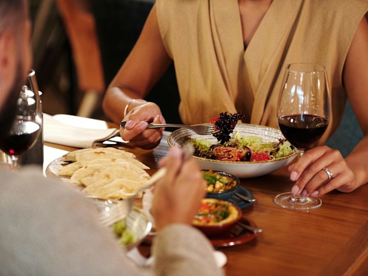 Fotografía de una cena de vino con una persona desenfocada de fondo