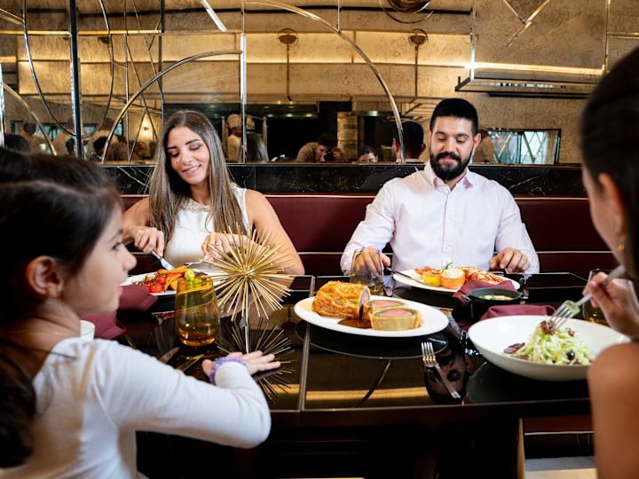 Tribeca Market. family enjoying dinner entrees in the dining room