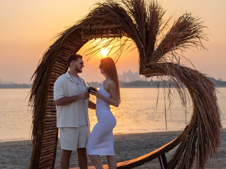 夕暮れ時のビーチで過ごすカップル