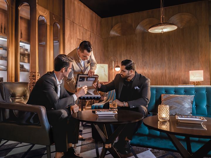 Group of men in lobby seating area with tables and chairs