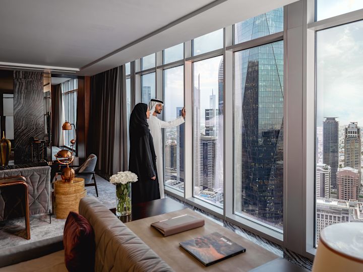 Man and woman in guest room looking out at city view