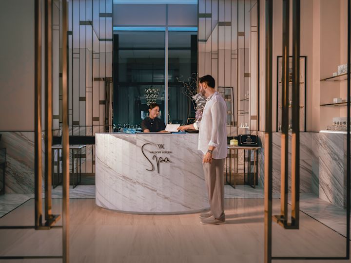 Spa reception with man handing paper across to staff member