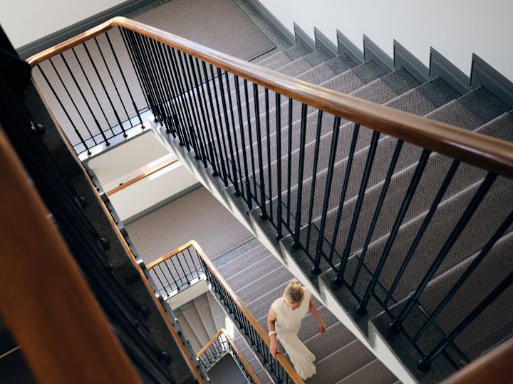 Mulher subindo uma escada em espiral tomada de cima