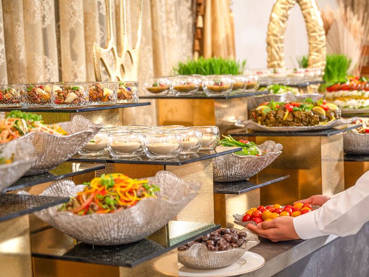 Person Setting Food in Bowls on a Counter