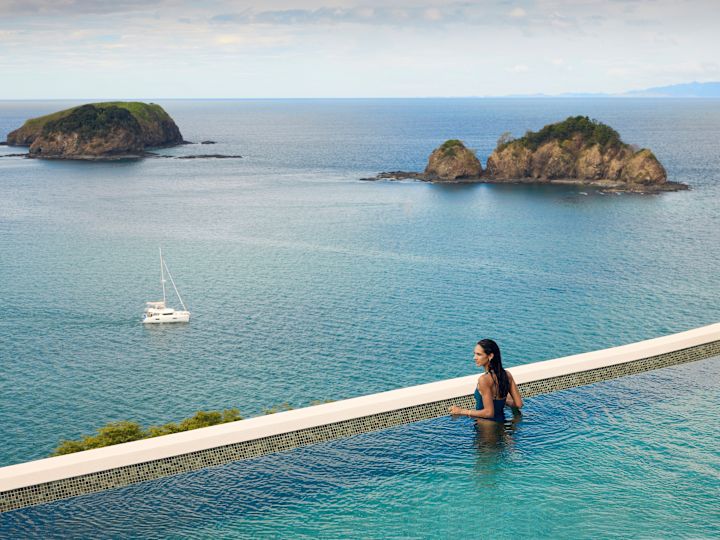 Woman Looking at the Ocean from Outdoor Pool Area