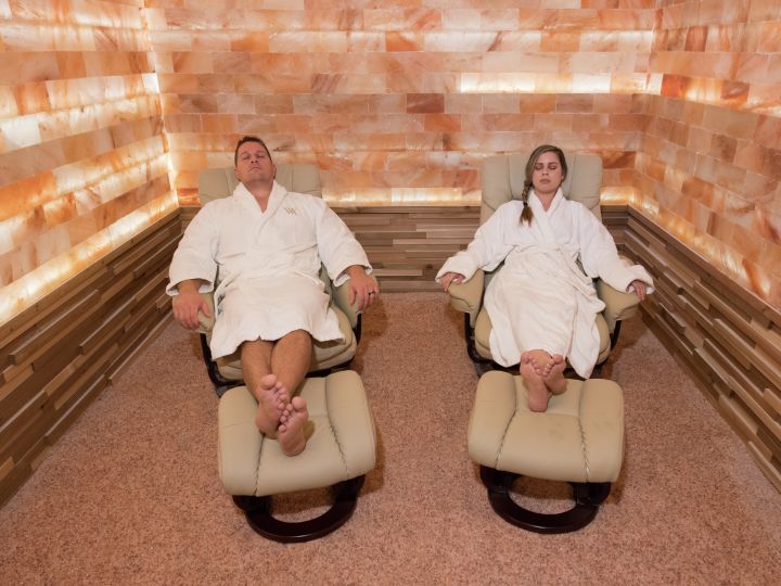 Couple lying in reclining chairs in salt room having Himalayan Salt Therapy