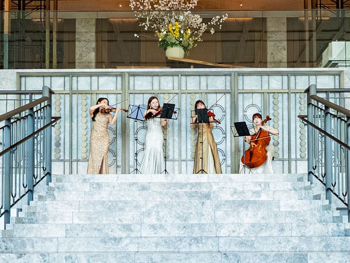 Quatre musiciennes jouent de la musique dans des robes formelles.