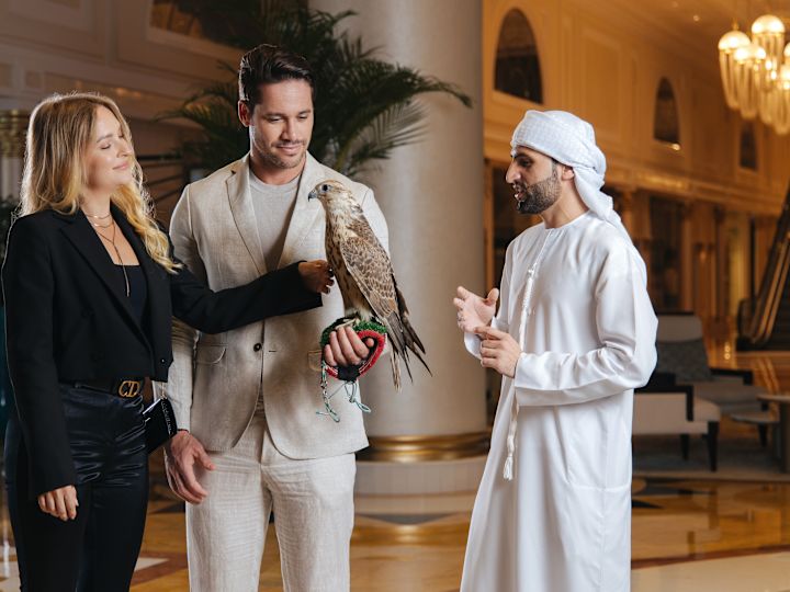 Man with Couple Holding a Falcon at the Hotel