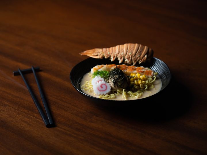 Small bowl of food on table, with lobster